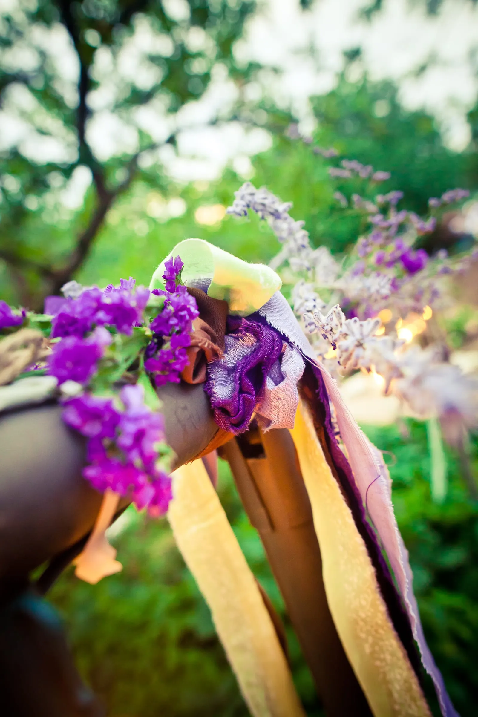 Purple flowers and ribbons decorating an outdoor wedding