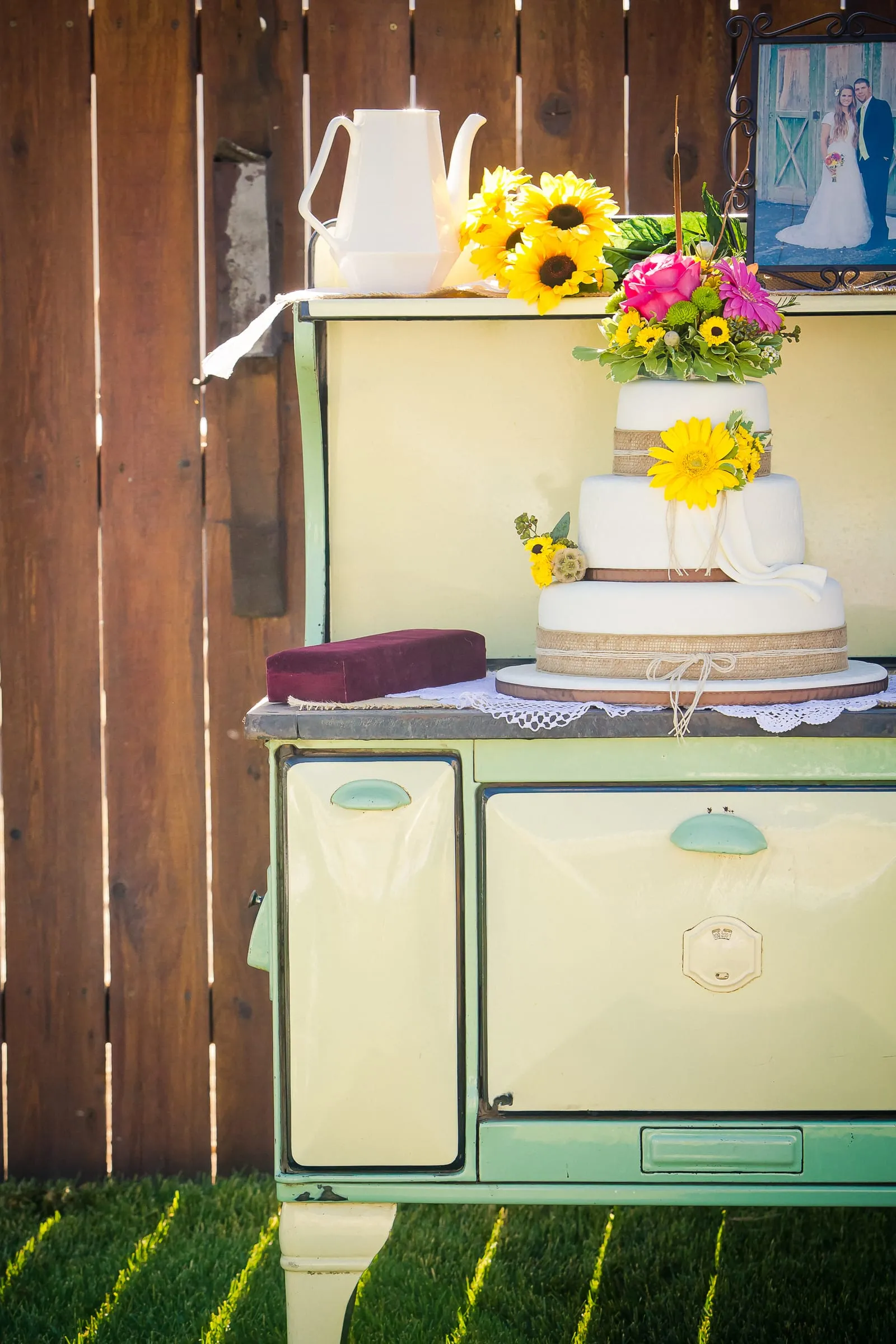 Wedding cake and sunflowers displayed on a vintage stove