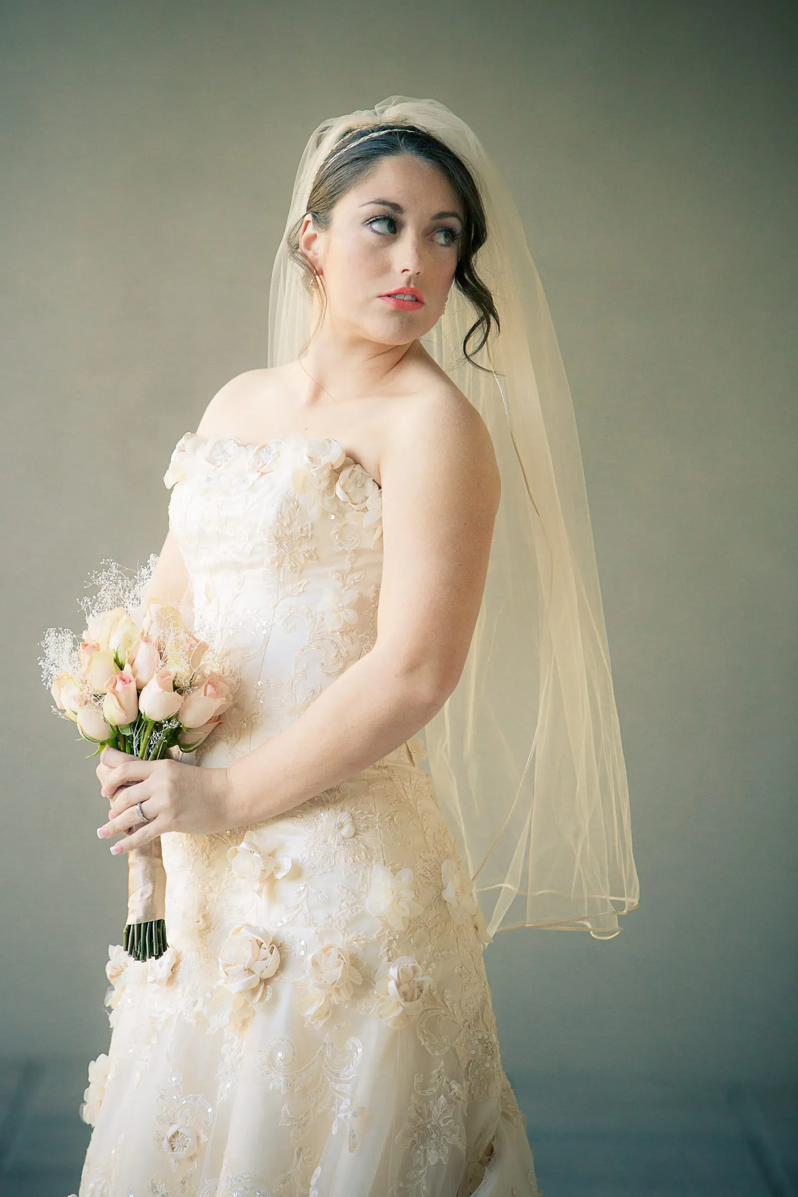 Bride holding her bouquet in soft window light
