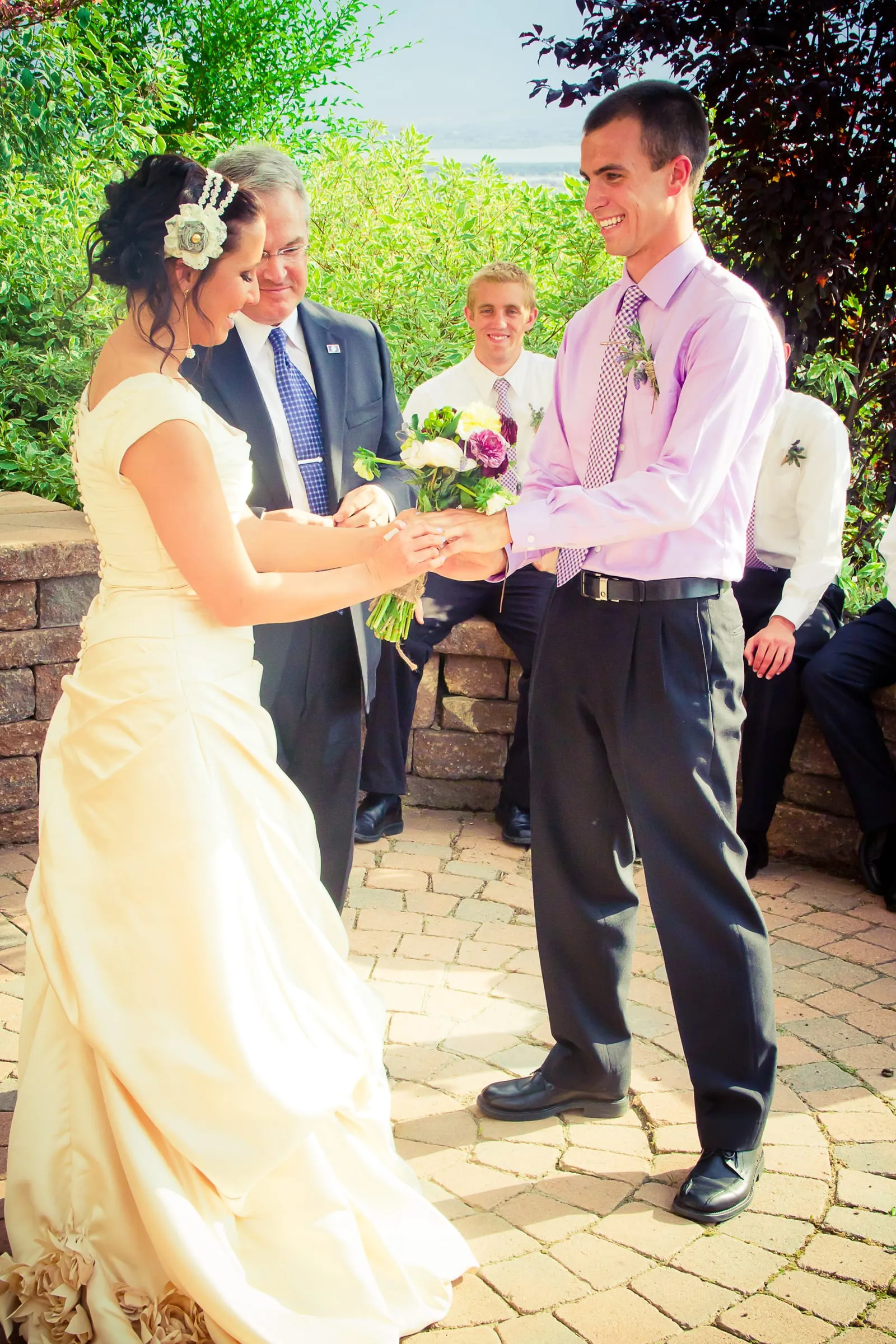 Bride and groom exchanging rings during an outdoor ceremony