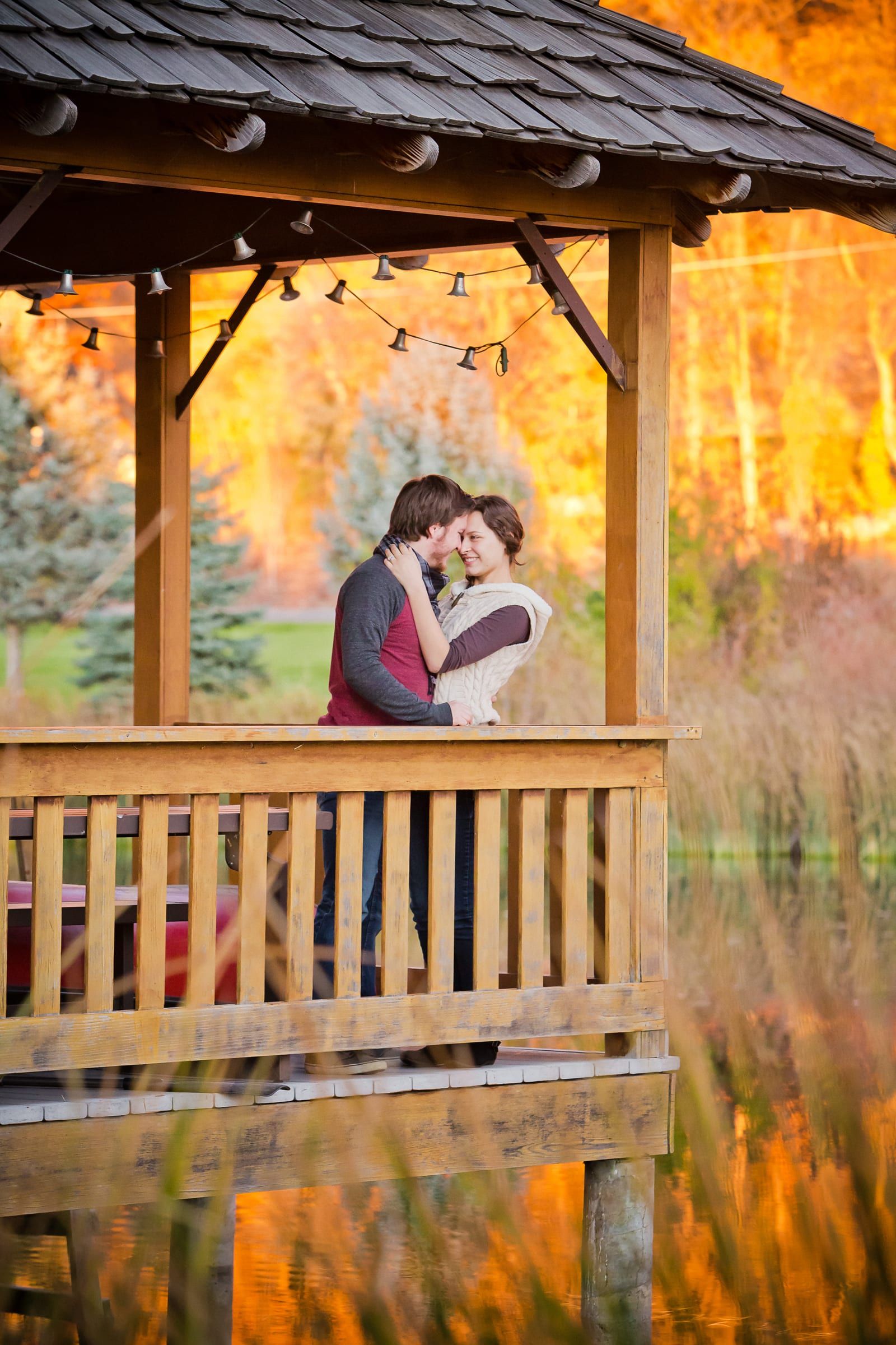Couple on a wooden gazebo surrounded by bright fall color
