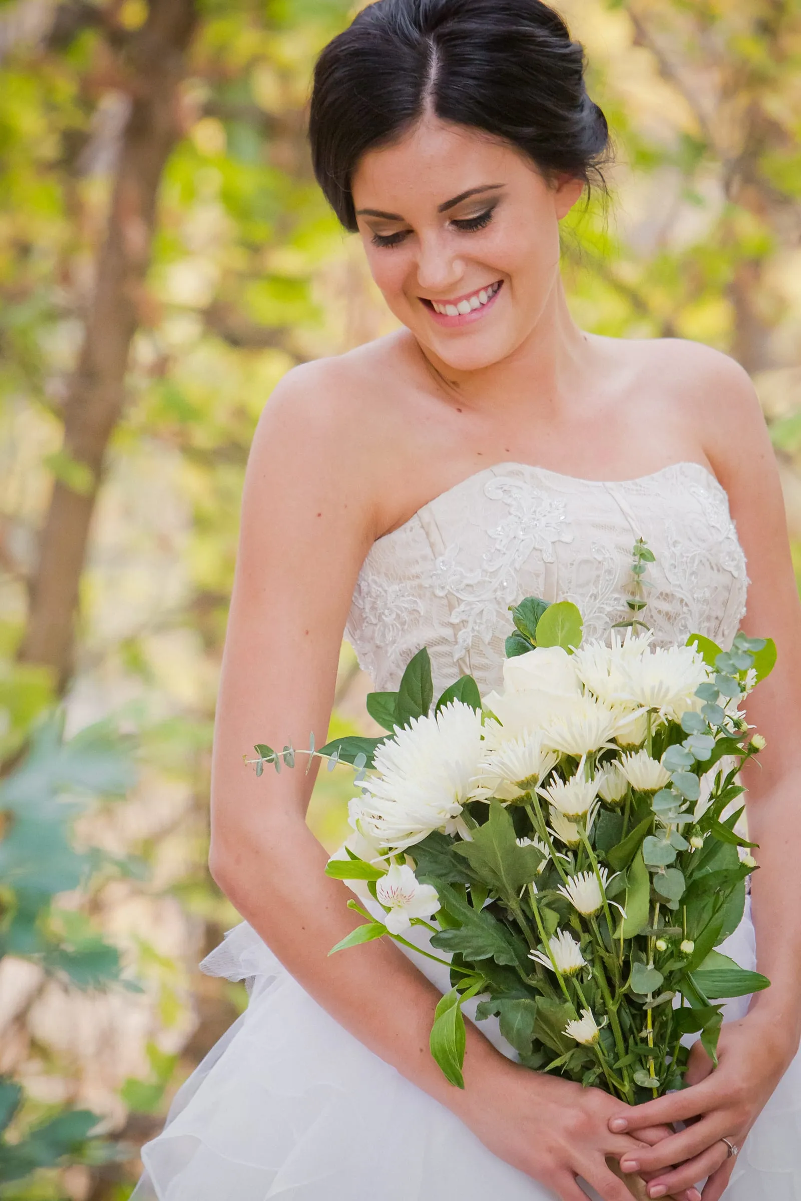 Smiling bride holding a bouquet of white roses