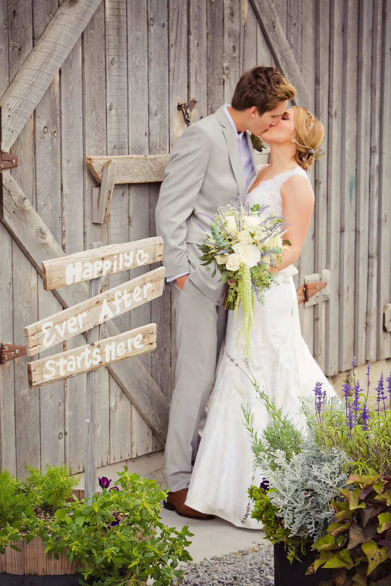 Bride and groom by a rustic barn-wood door