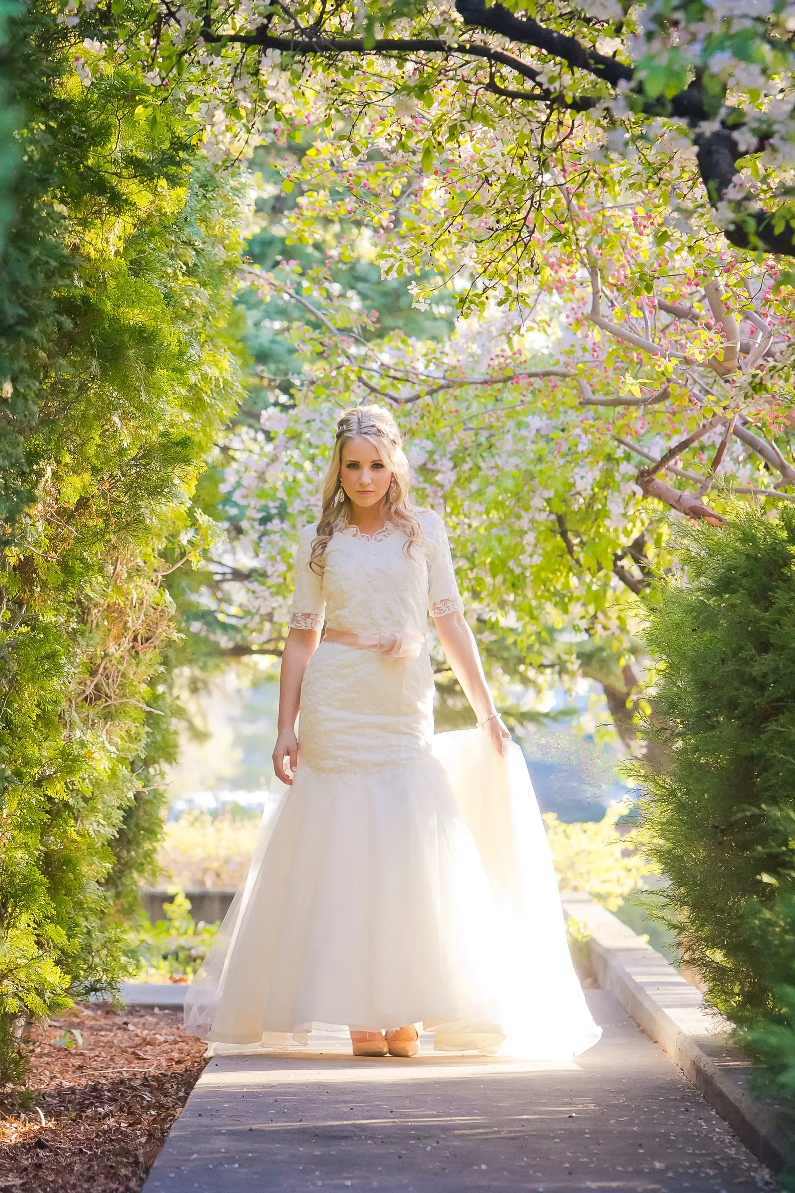 Bride on a garden path framed by lush greenery