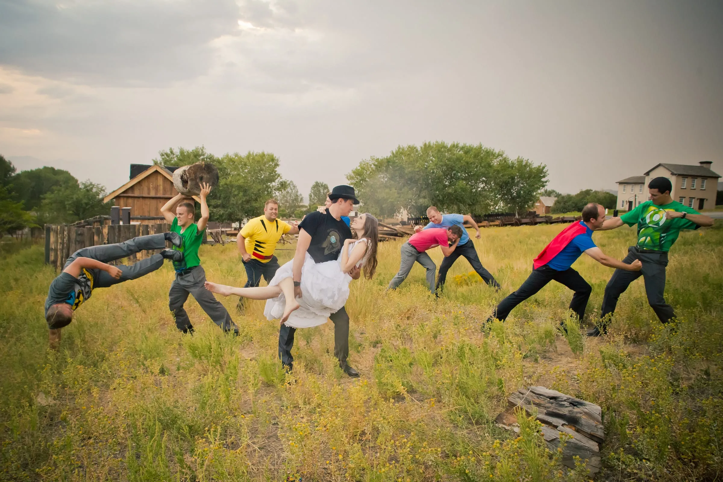 Bride and groom playing football with the wedding party on a grassy field