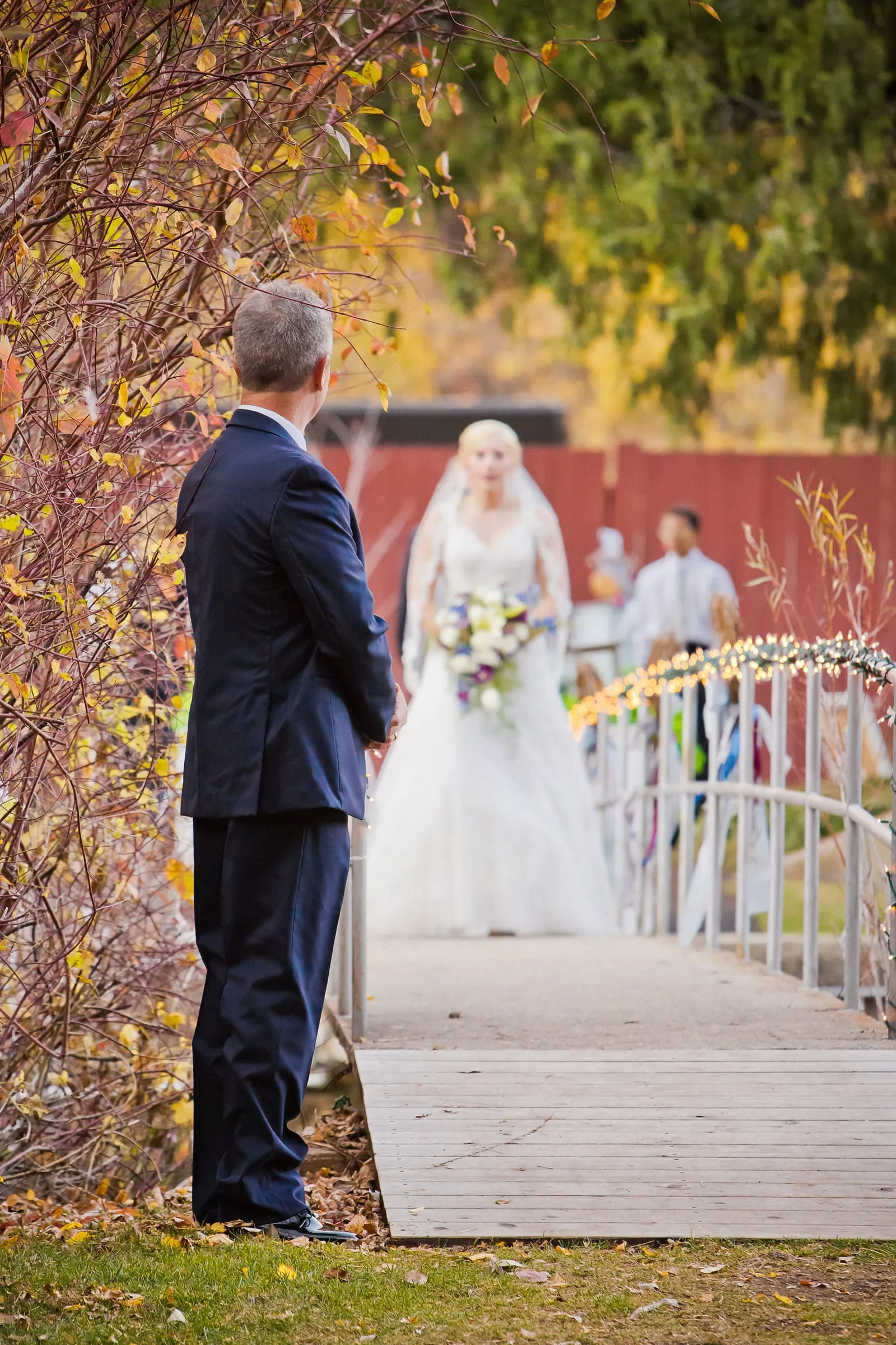Groom and bride on a white footbridge in a garden