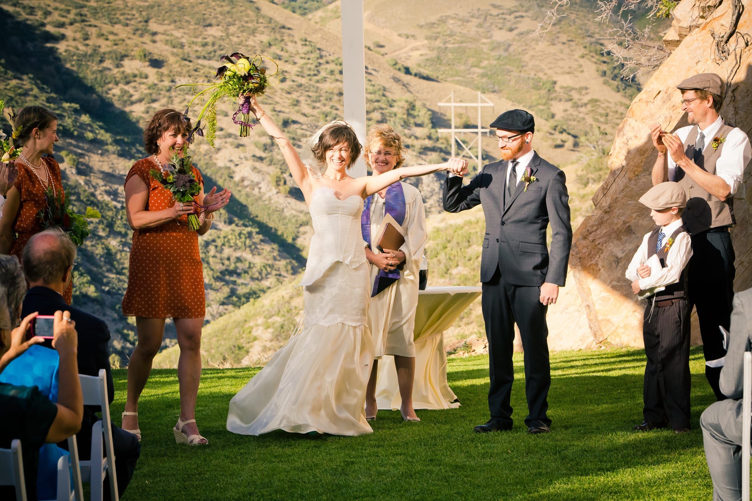Joyful outdoor wedding ceremony with red rock cliffs behind the guests
