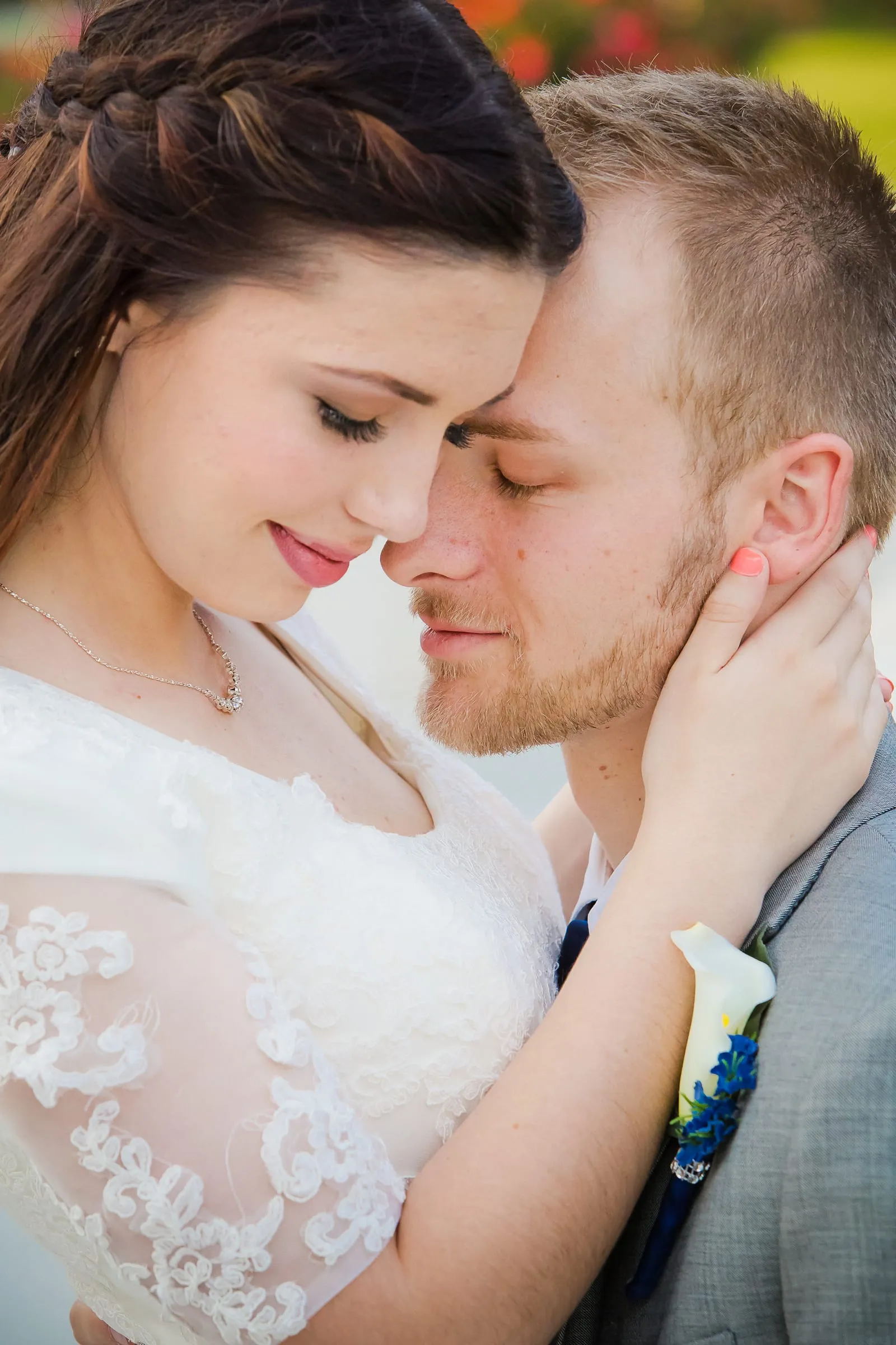 Bride and groom forehead to forehead in a close portrait