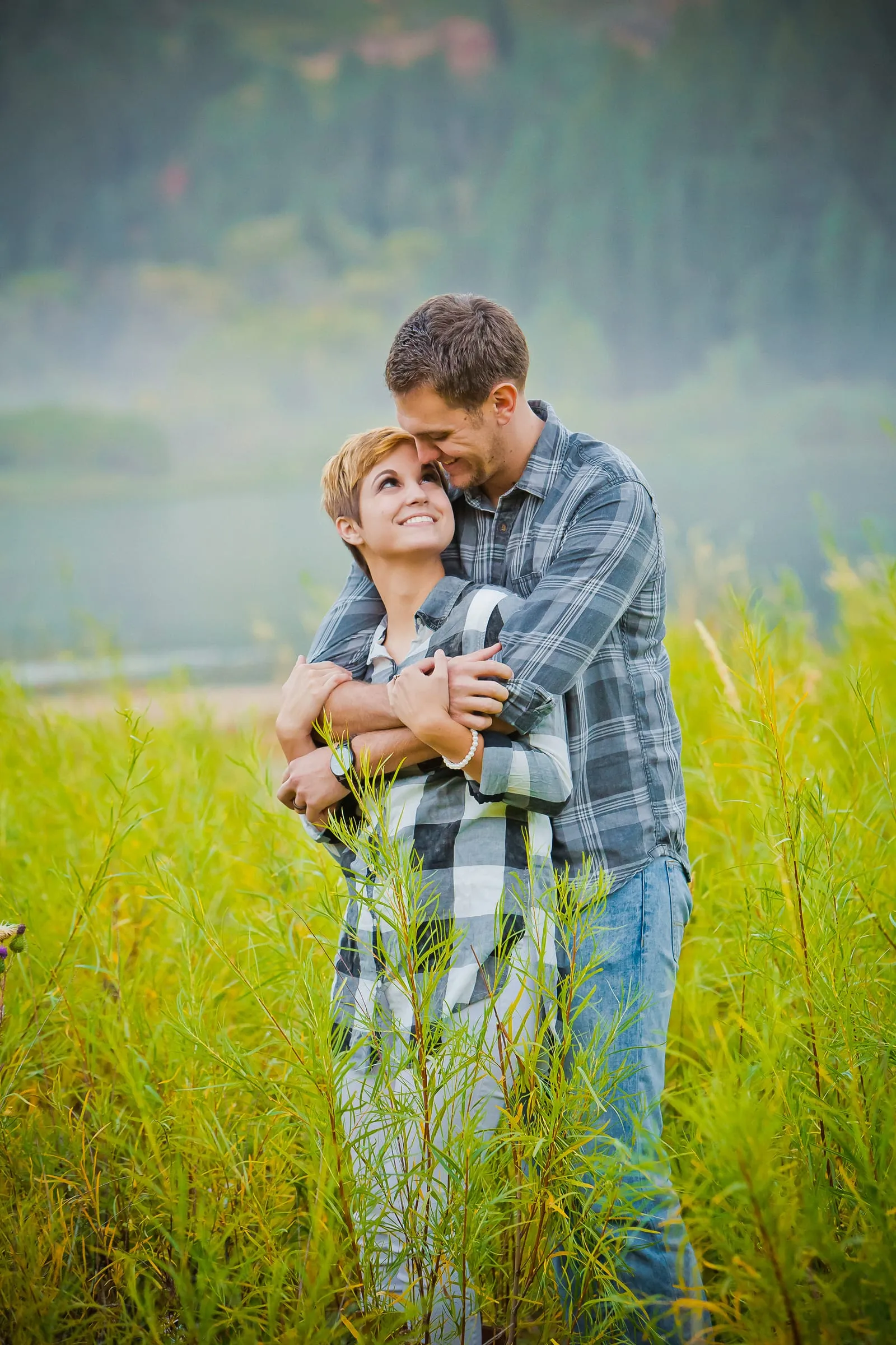 Couple embracing in tall green grass