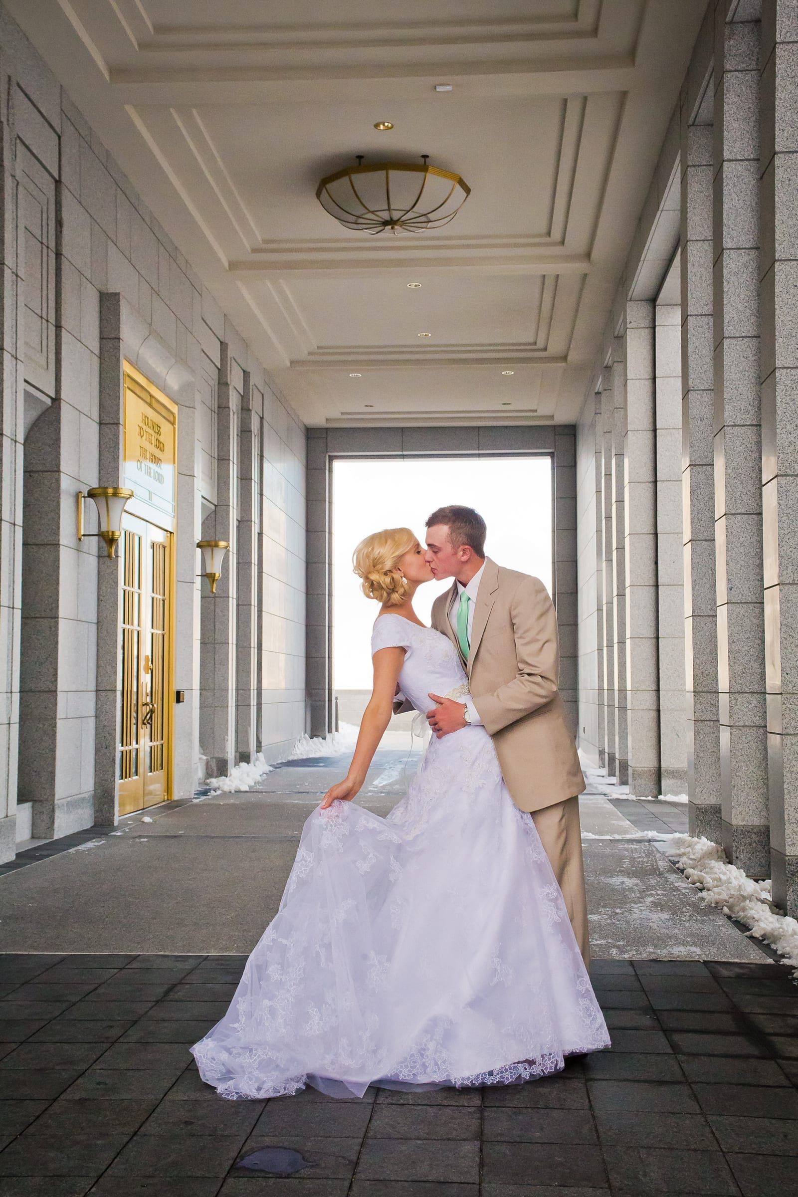 Bride and groom walking through a columned portico