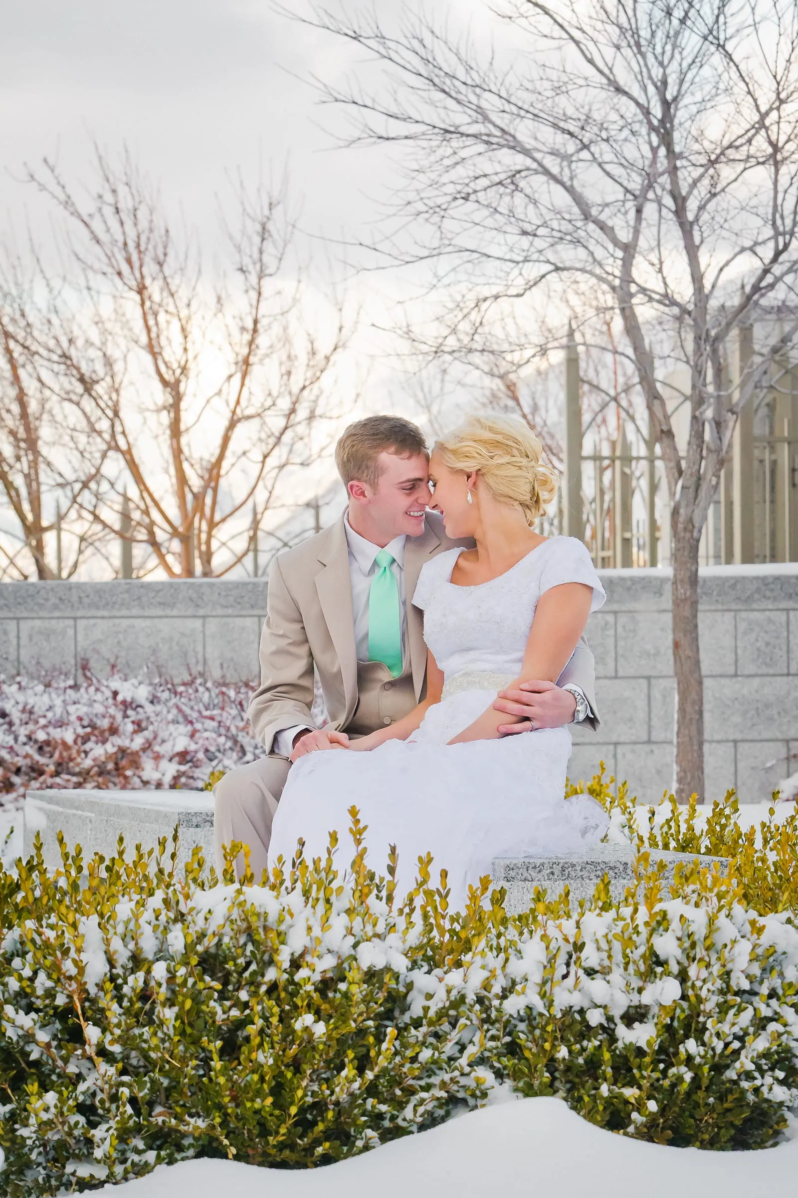 Bride and groom seated together in a snowy winter garden