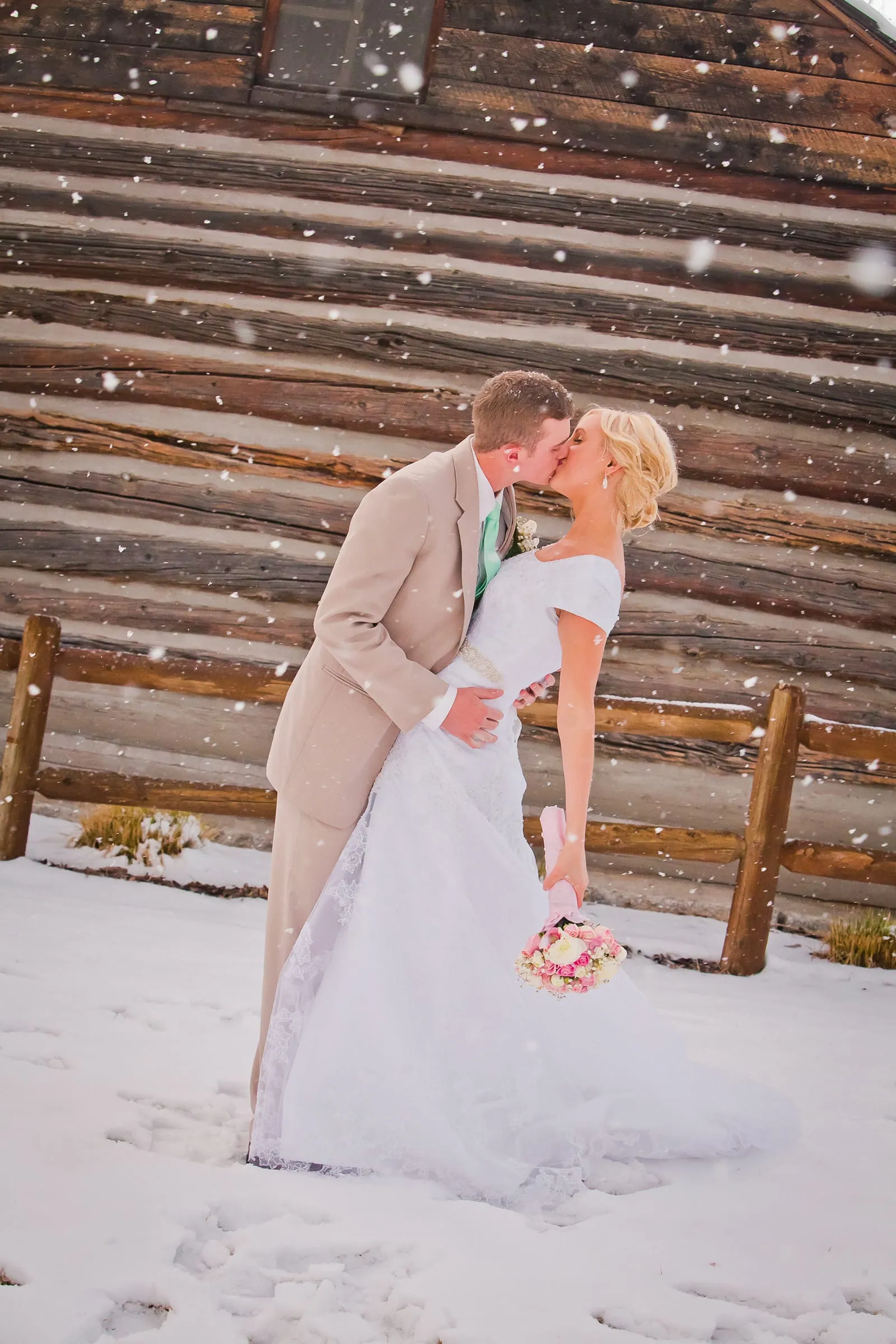 Couple sharing a kiss on snowy log steps