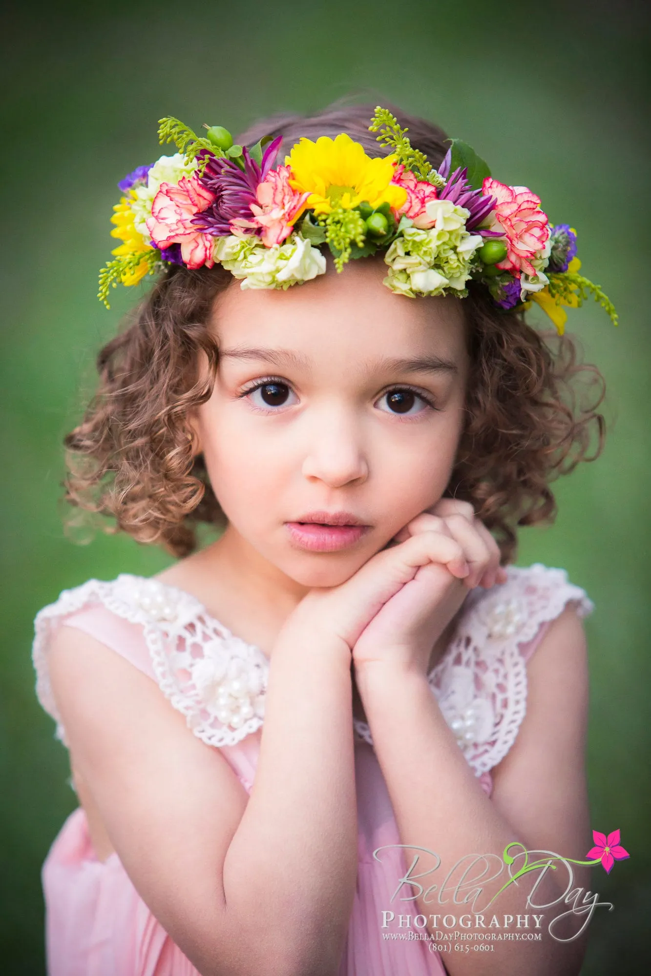 Little girl in a flower crown resting her chin on her hands